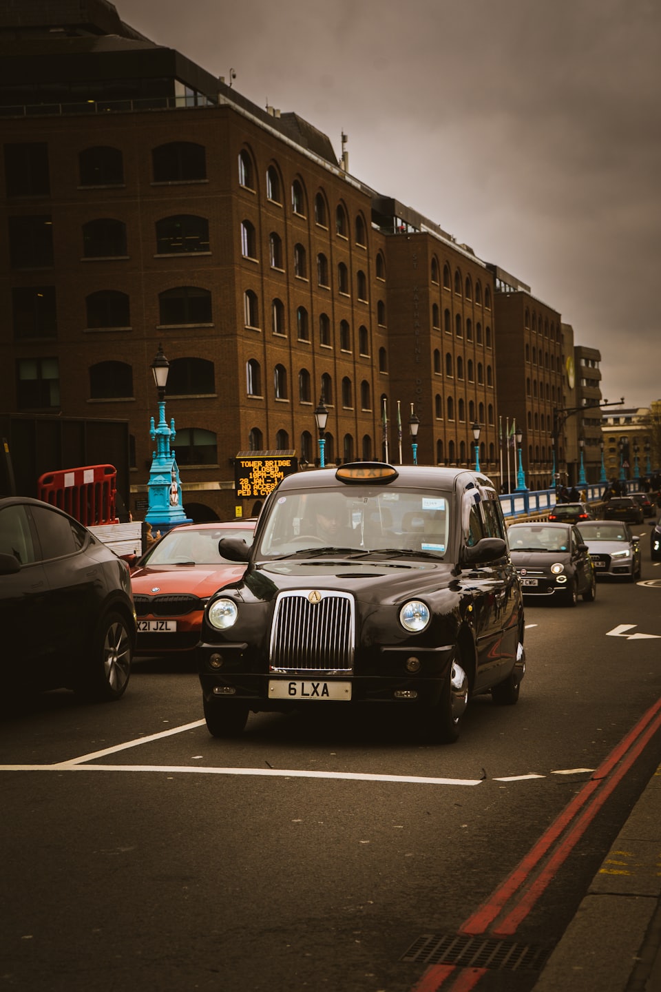 Black taxi on busy London street.